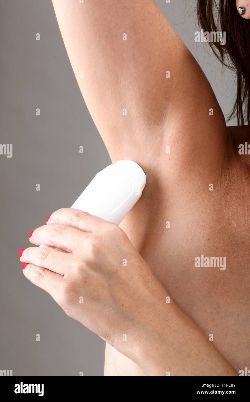 Modello rilasciato. La donna si applica le ascelle roll-on deodorante. Foto Stock