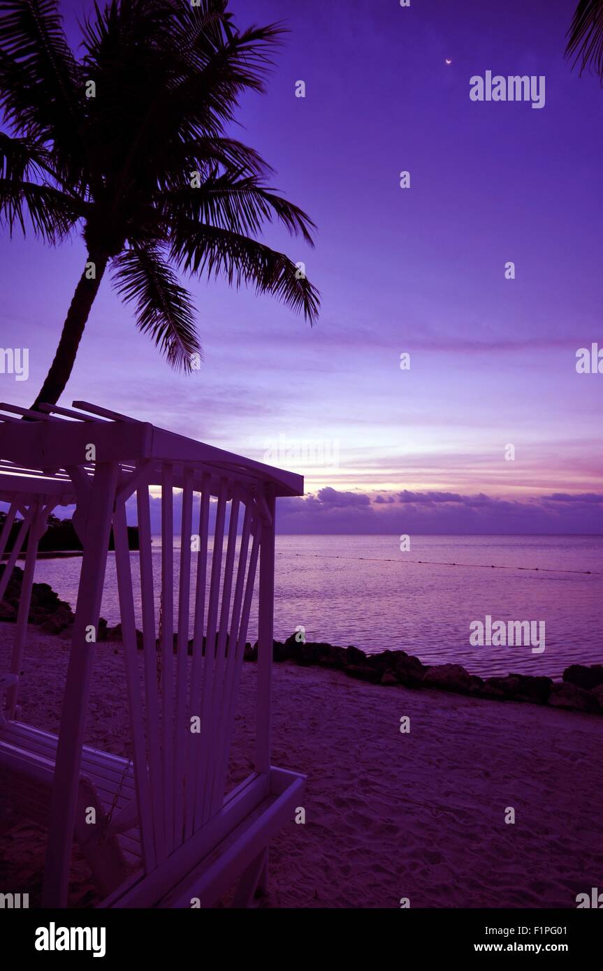 Rilassatevi nel tramonto. Tramonto tropicale, Palm, oceano, banco e la spiaggia. Pinky tramonto in qualche luogo tropicale. Foto Stock
