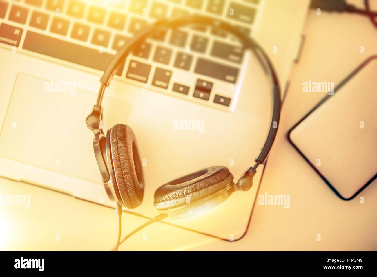 L'ascolto di musica online. Cuffie sul computer portatile e disco rigido esterno per la memorizzazione di musica. Foto Stock