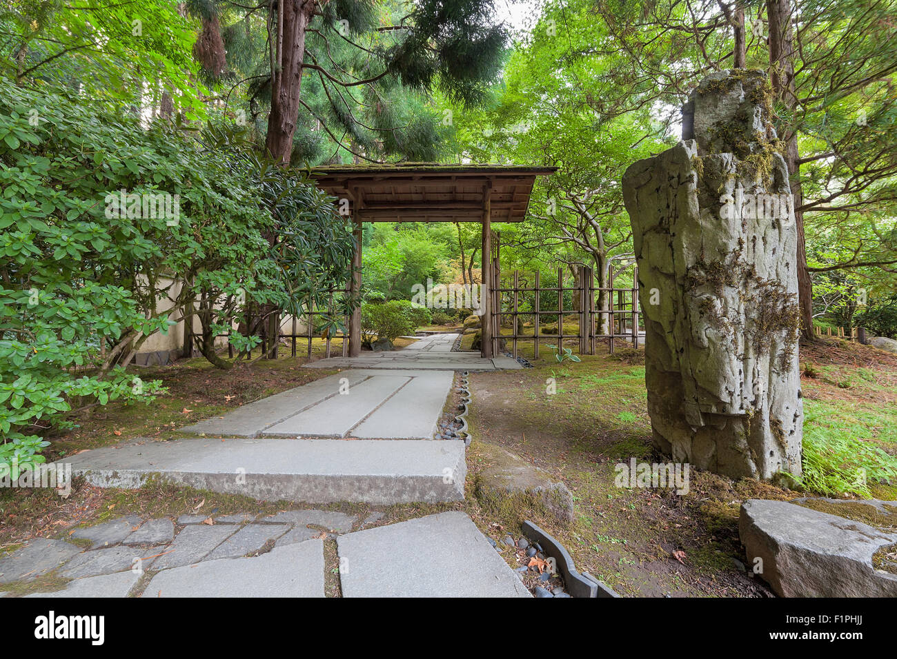 Percorso di pietra il legno con la struttura di entrata e il paesaggio di rocce al giardino giapponese Foto Stock