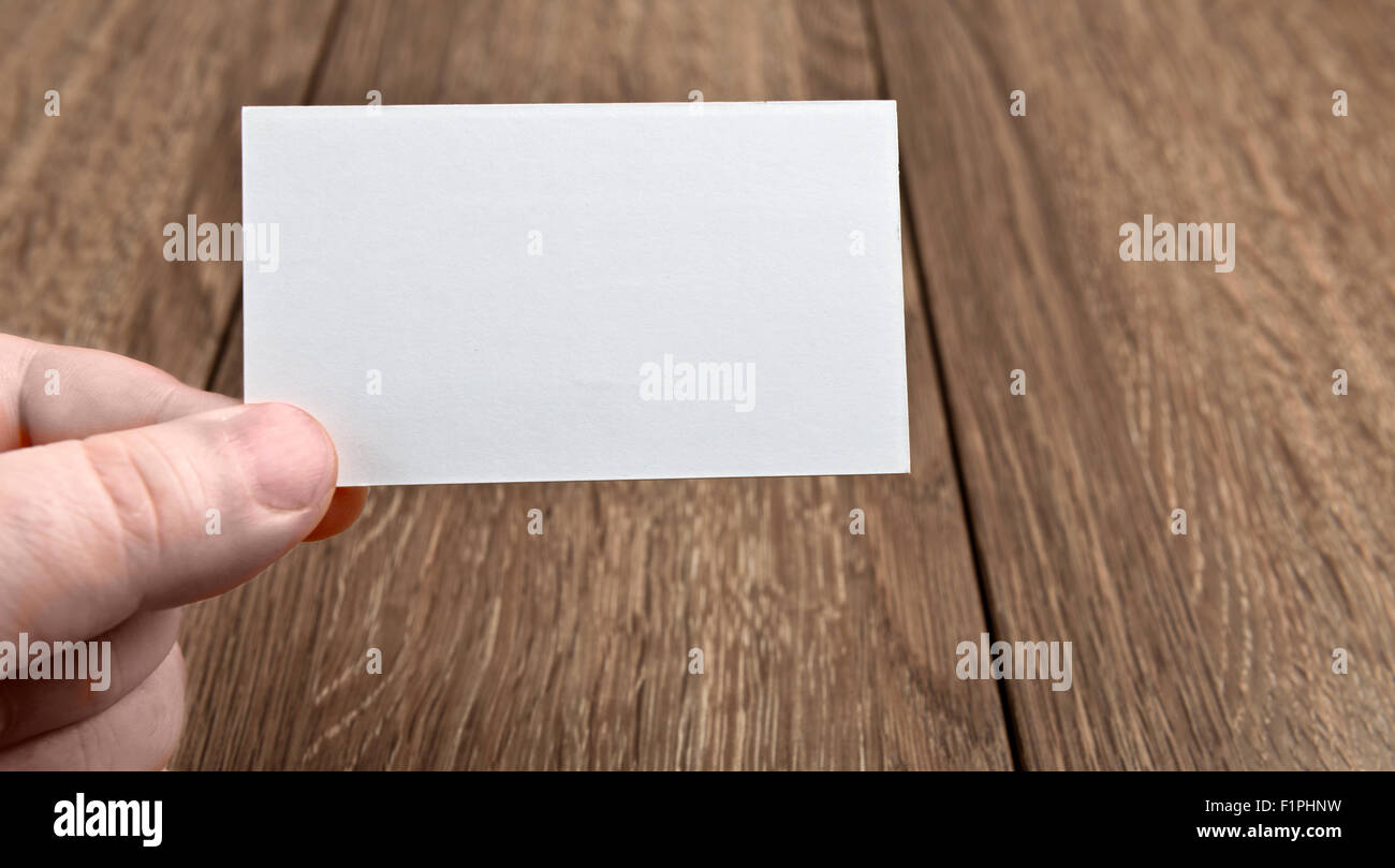 Business card in mano sul tavolo di legno Foto Stock