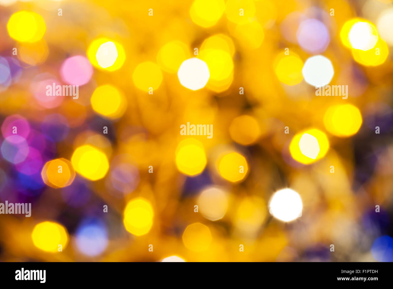 Abstract sfondo sfocato - giallo e rosa scintillanti luci di Natale bokeh di le ghirlande elettriche su albero di Natale Foto Stock