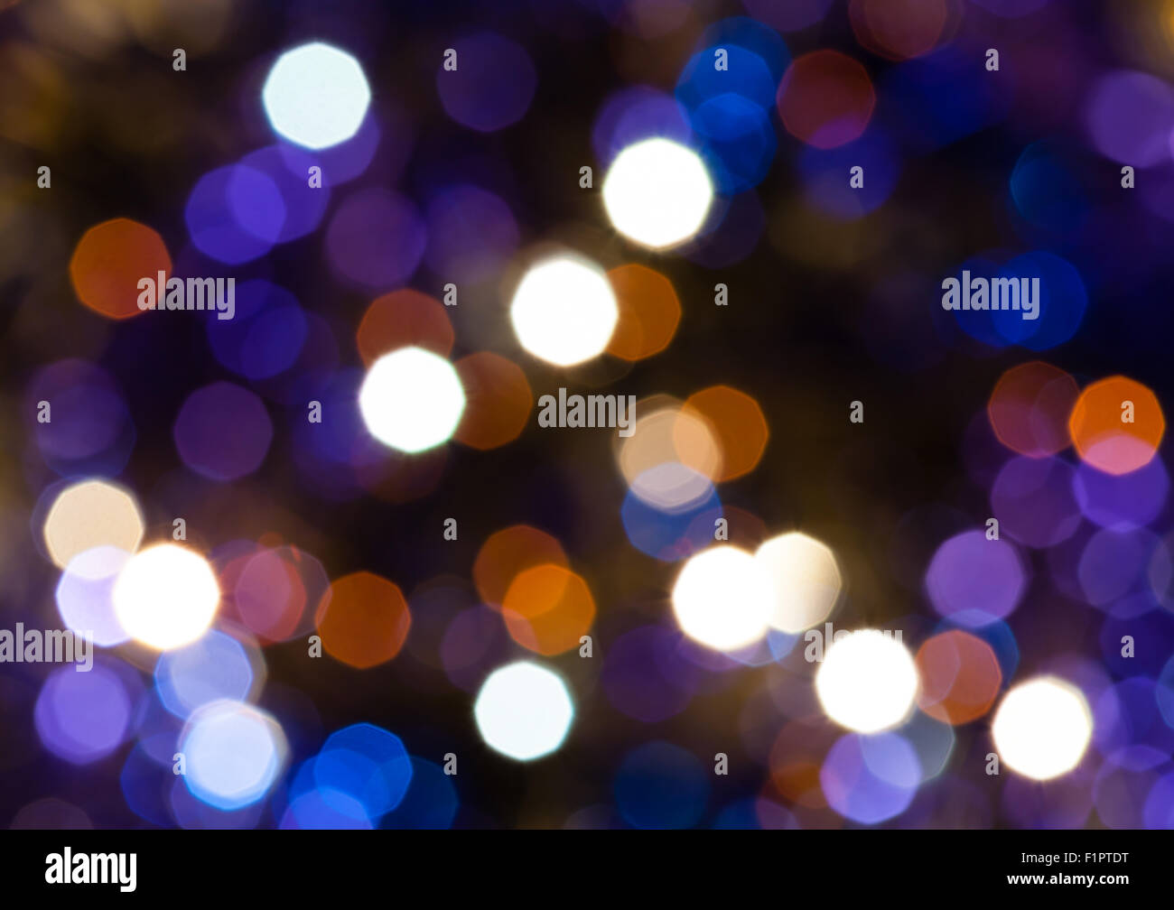 Abstract sfondo sfocato - blu scuro e viola scintillanti luci di Natale bokeh di le ghirlande elettriche su albero di Natale Foto Stock