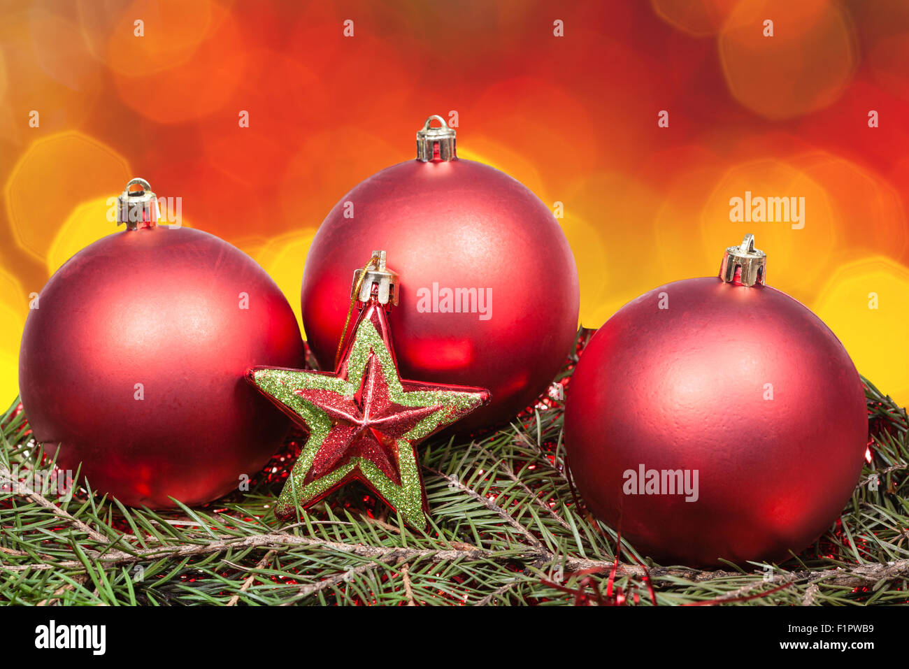 Xmas ancora vita - rosso baubles, stella, albero verde con sfocati di rosso e di giallo le luci di Natale sfondo bokeh di fondo Foto Stock