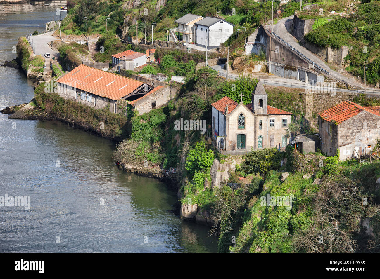 Vecchia chiesa e negli edifici a riverside collinare del fiume Douro nella città di Vila Nova de Gaia in Portogallo. Foto Stock