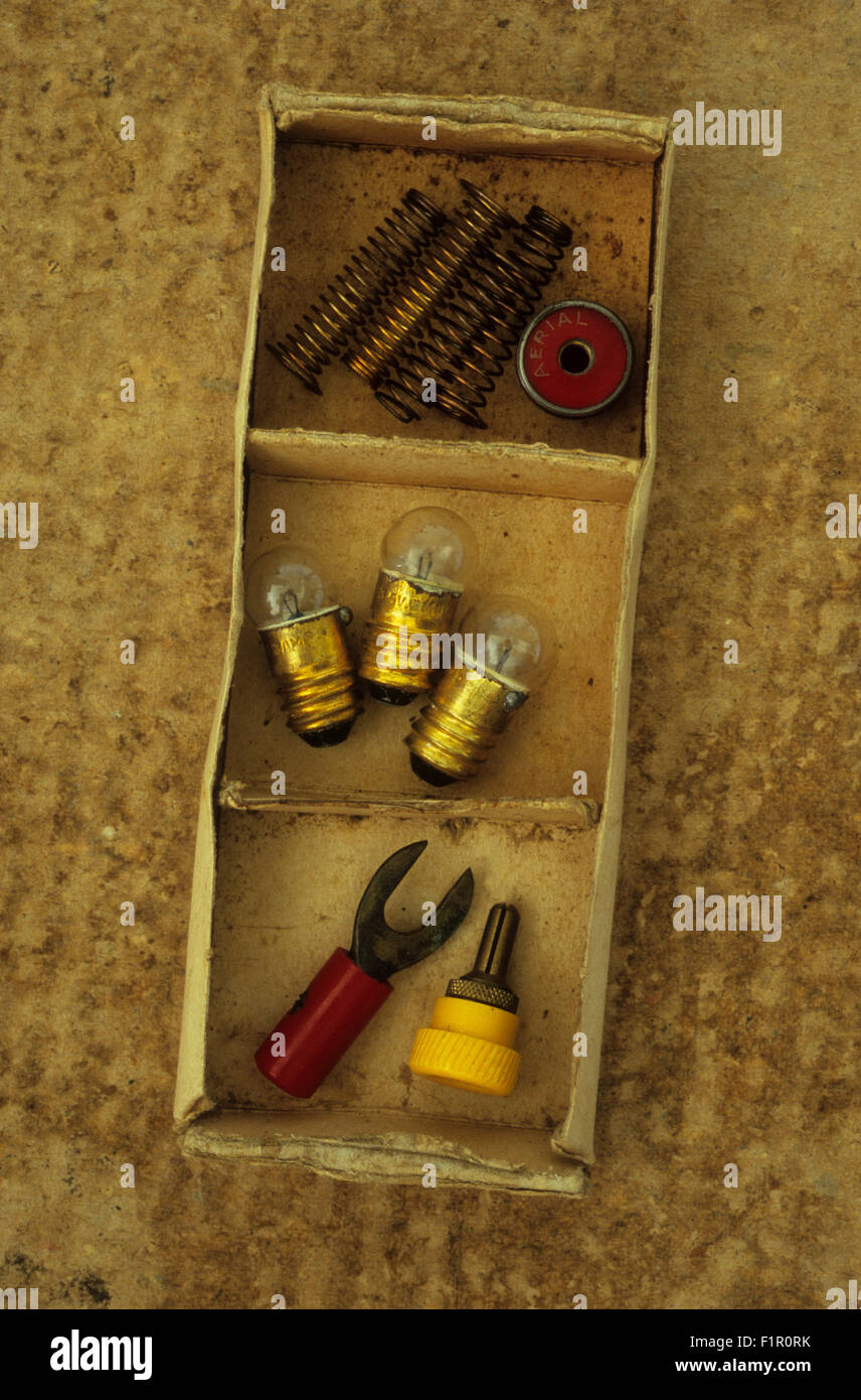 Piccole scatole di cartone con tre scomparti contenenti torcia lampadine dei connettori elettrici e molle Foto Stock