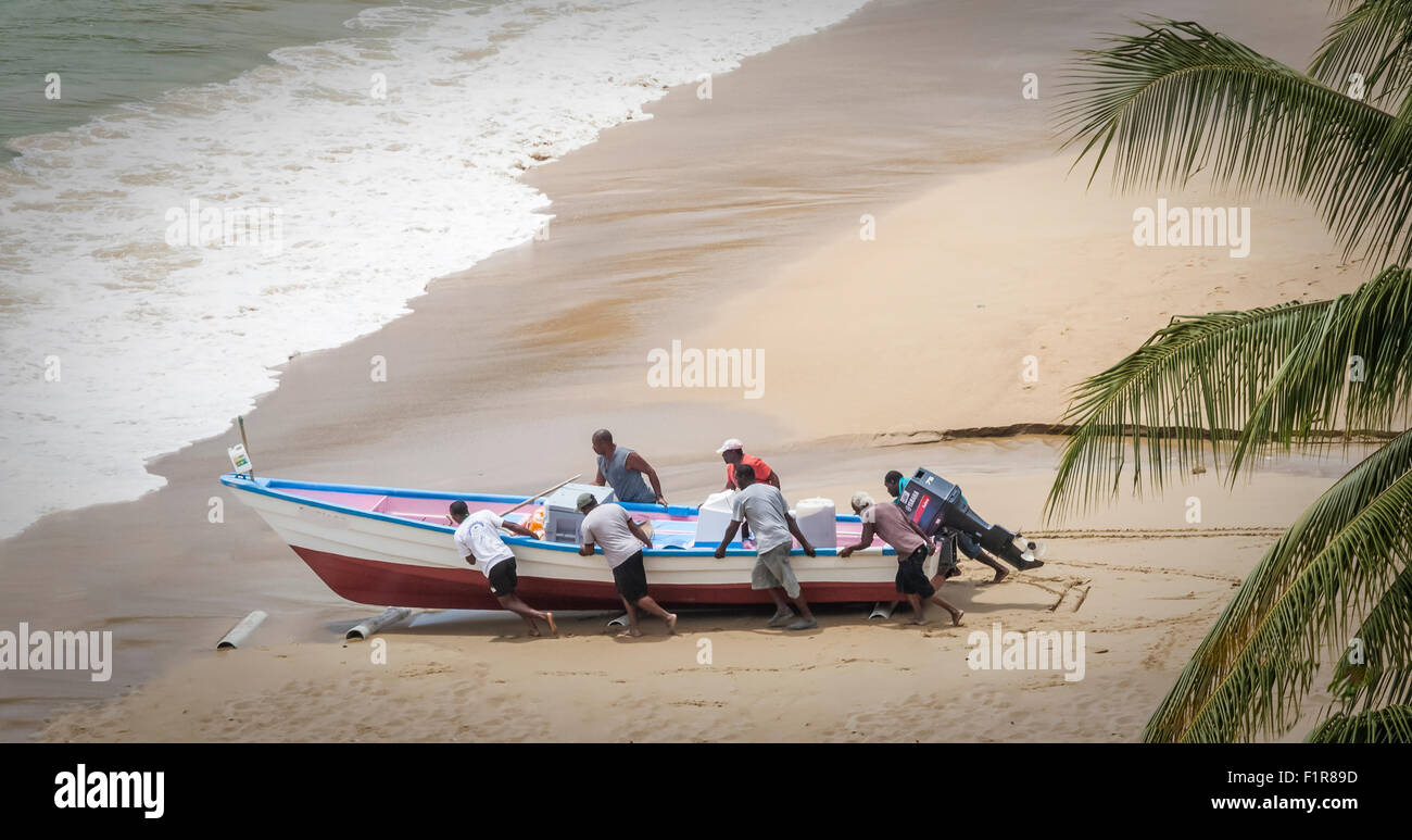 Spingere i pescatori delle possibilità di pesca loro bout fuori oltre le sabbie in surf in spiaggia di Castara, Tobego, Caraibi Foto Stock Spingere i pescatori delle possibilità di pesca loro bout fuori oltre le sabbie in surf in spiaggia di Castara, Tobego, Caraibi Foto Stock