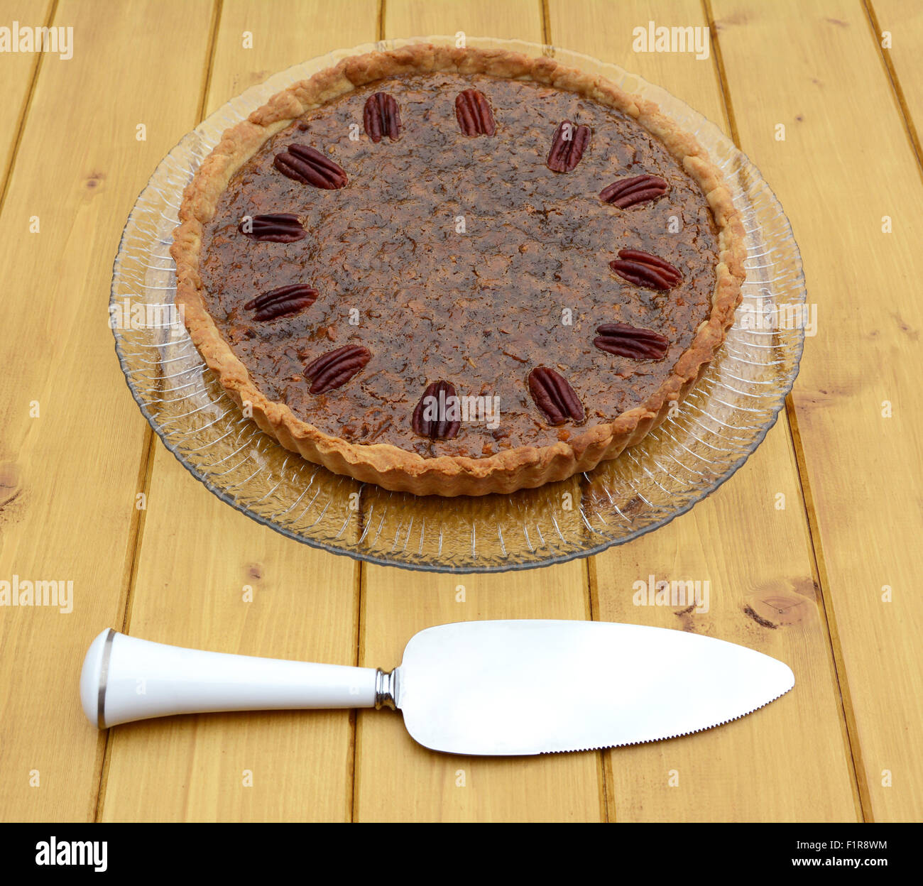 Server di torta utensile con fatti in casa torta alle noci pecan su una lastra di vetro Foto Stock