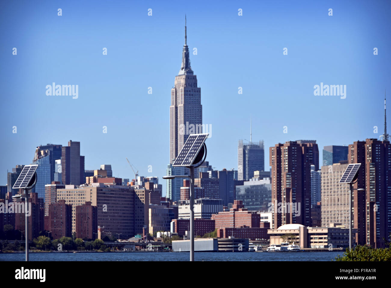 Pannelli solari in East River State Park a Brooklyn, NY con una vista di Manhattan e l'Empire State building in background. Foto Stock