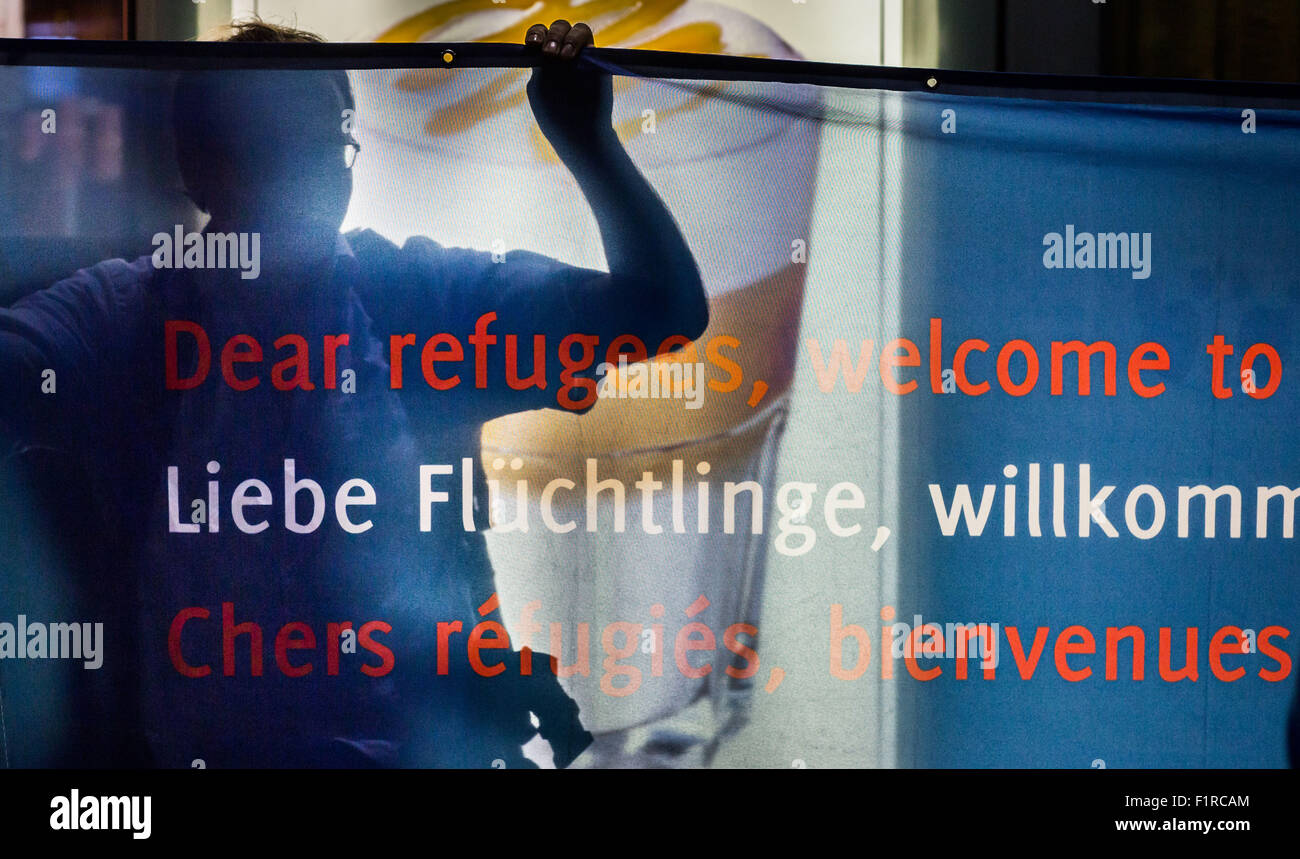 Un volontario saluta i rifugiati con un banner presso la stazione ferroviaria principale di Francoforte sul Meno, Germania, 05 settembre 2015. I rifugiati sono presi ai centri di accoglienza. Foto: Frank Rumpenhorst/dpa Foto Stock