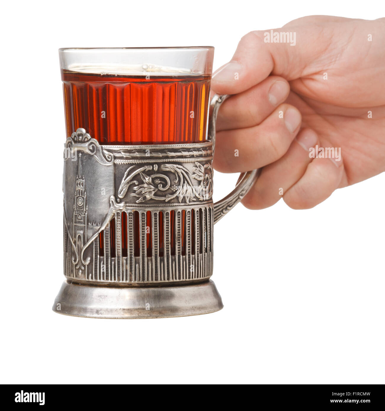 Mano che tiene un sovietico vetro sfaccettate di tè in vetro vintage-titolare (podstakannik) Foto Stock