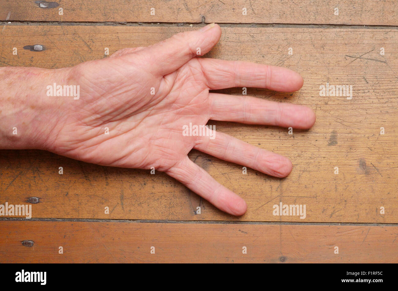 Old man mano gesticolando su uno sfondo di legno Foto Stock