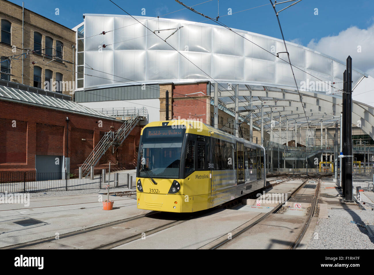 Il rinnovato Victoria Station a Manchester, come Metrolink LRT tram emerge Foto Stock