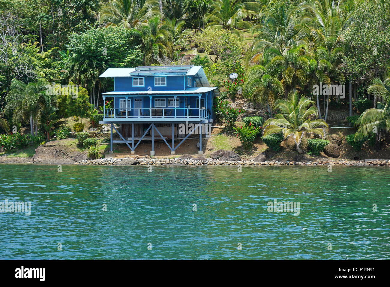 Off grid home costiere con lussureggiante vegetazione tropicale, dei Caraibi shore di Panama, Bocas del Toro, America Centrale Foto Stock