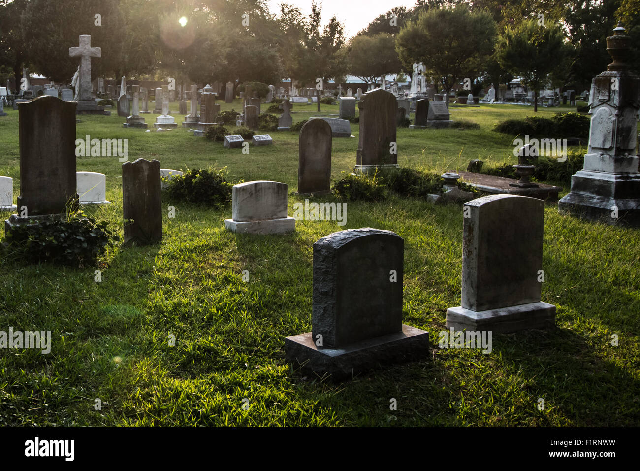 Gli oggetti contrassegnati per la rimozione definitiva in un cimitero al crepuscolo. Foto Stock