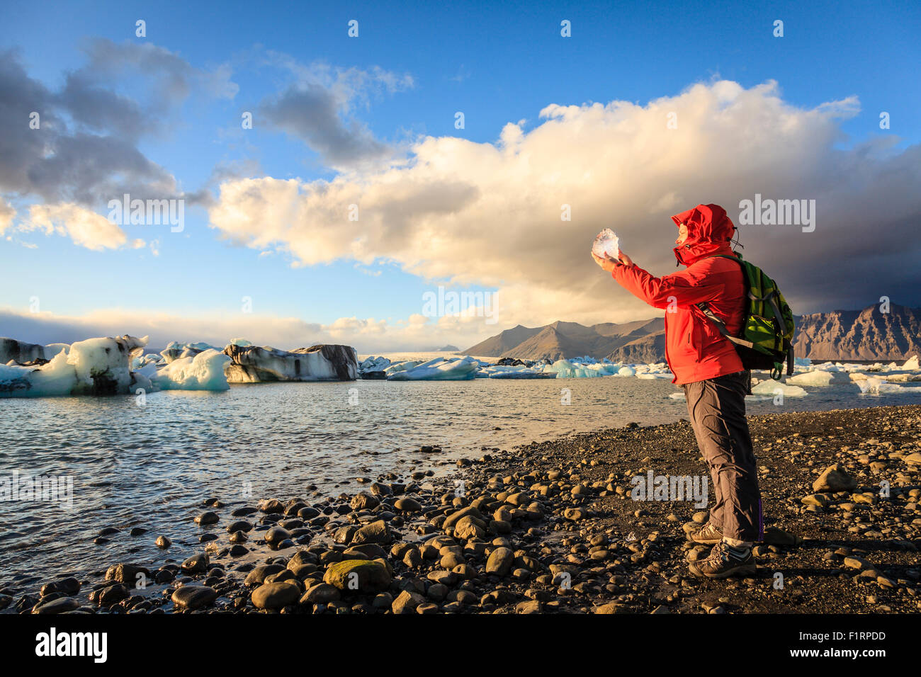 La donna è in possesso di un pezzo di ghiaccio dal ghiacciaio a Jokulsarlon Laguna in Islanda Foto Stock