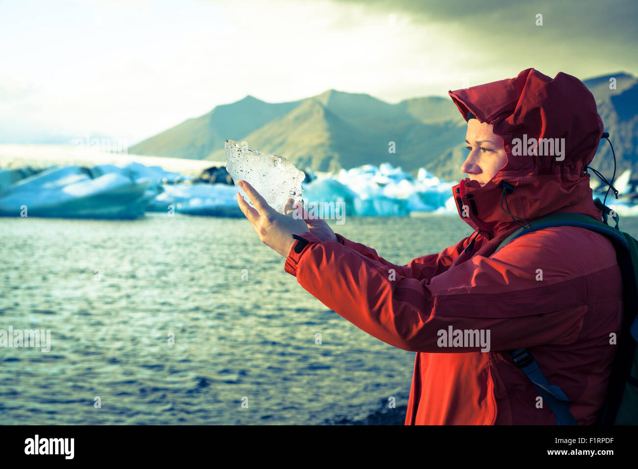 La donna è in possesso di un pezzo di ghiaccio dal ghiacciaio a Jokulsarlon Laguna in Islanda Foto Stock