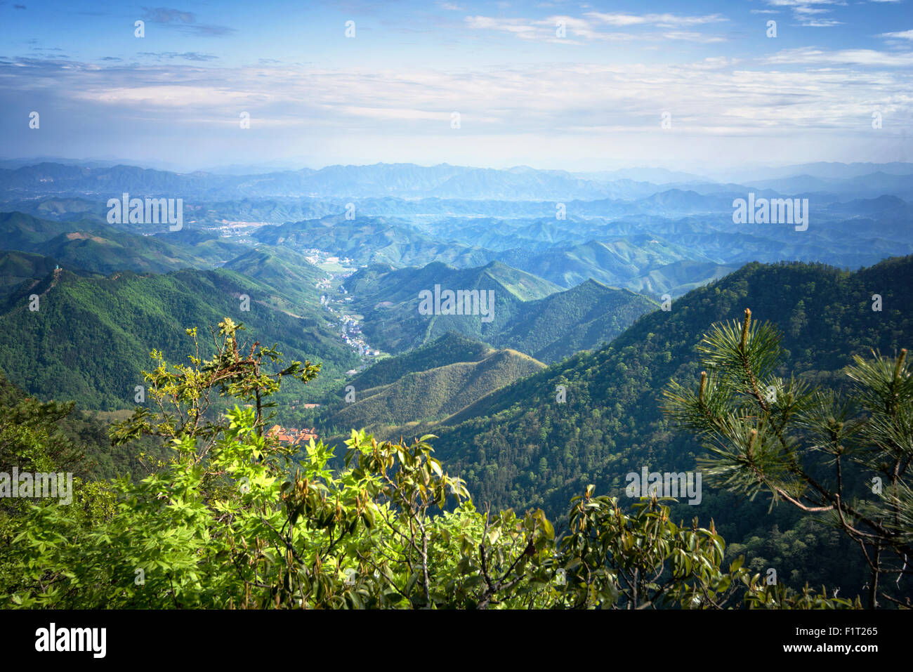 Misty catene montuose e valle con villaggio come visto da Tian Shan um picco, Zhejiang, Cina e Asia Foto Stock