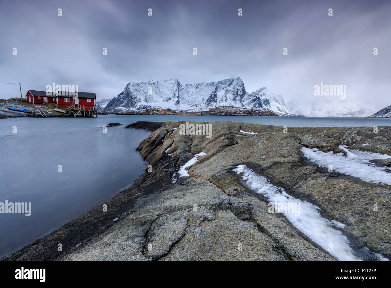 Tipico paesaggio di Hamnoy con red case di pescatori e le montagne innevate, Isole Lofoten in Norvegia, Scandinavia, Arctic Foto Stock