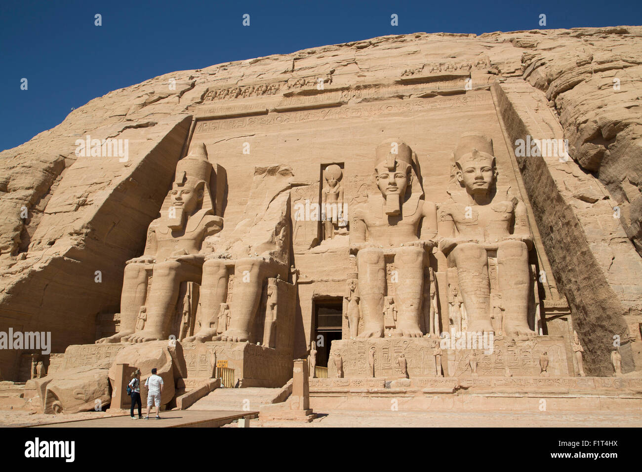 Turisti che si godono il sito, Colossi di Ramses II, Sun tempio di Abu Simbel, Sito Patrimonio Mondiale dell'UNESCO, Egitto, Nord Africa Foto Stock