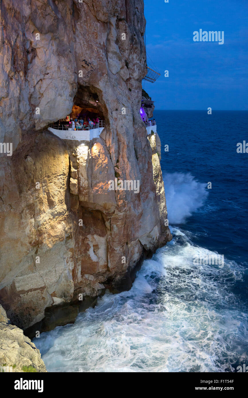 Bar costruito nella roccia grotte, Cova d'en Xoroi in serata, Cala en Porter, Menorca, isole Baleari, Spagna, Mediterraneo, Europa Foto Stock