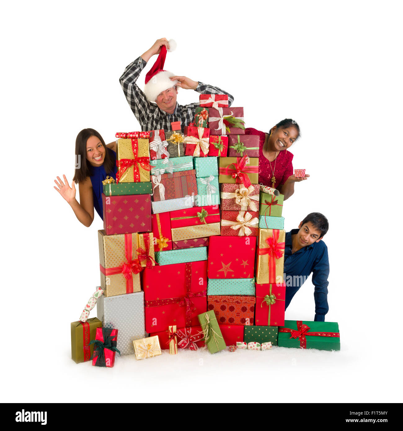 Razza mista famiglia vi saluto da dietro un enorme pila di regali di natale Foto Stock