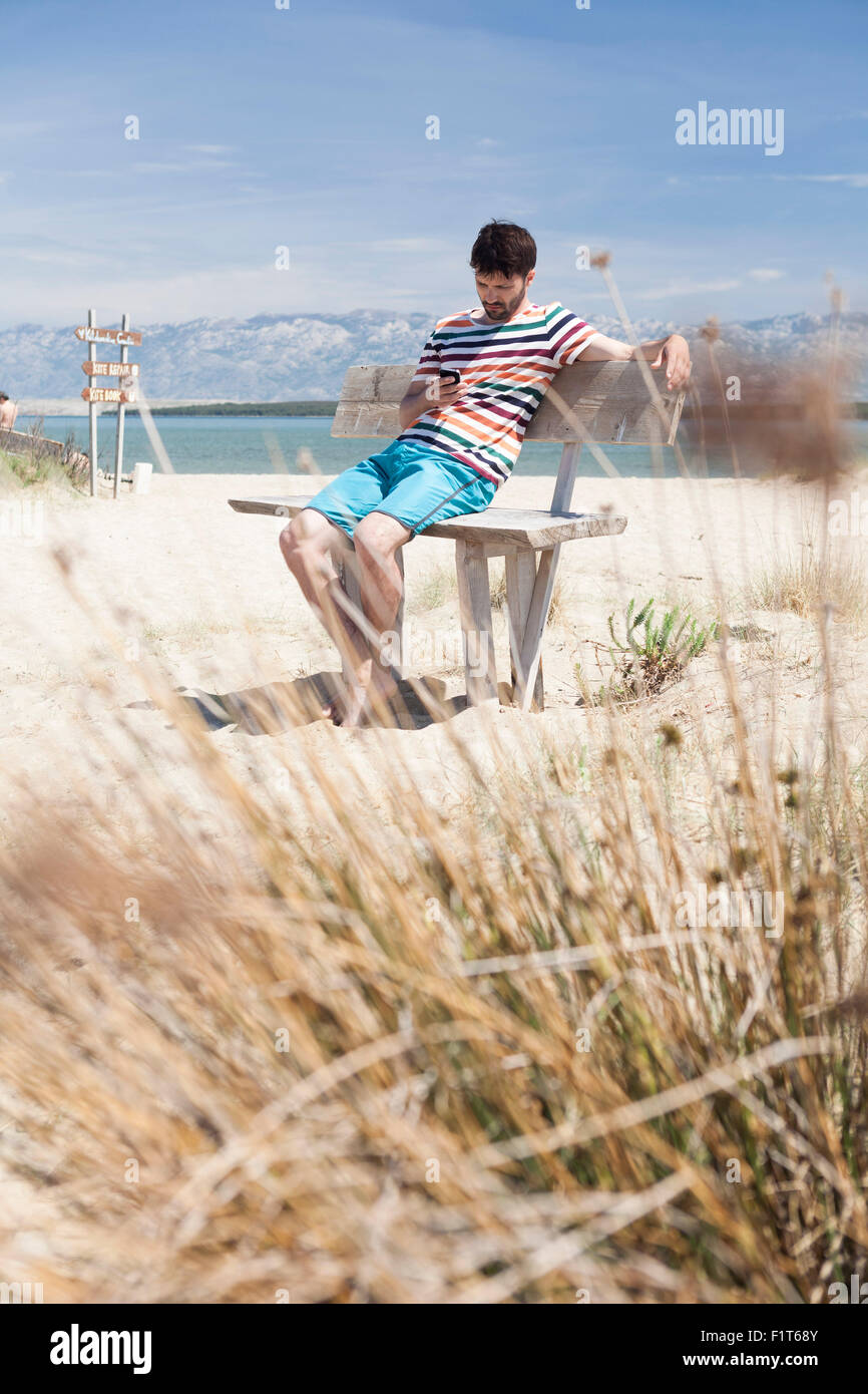 Giovane uomo con comodo sulla spiaggia Foto Stock
