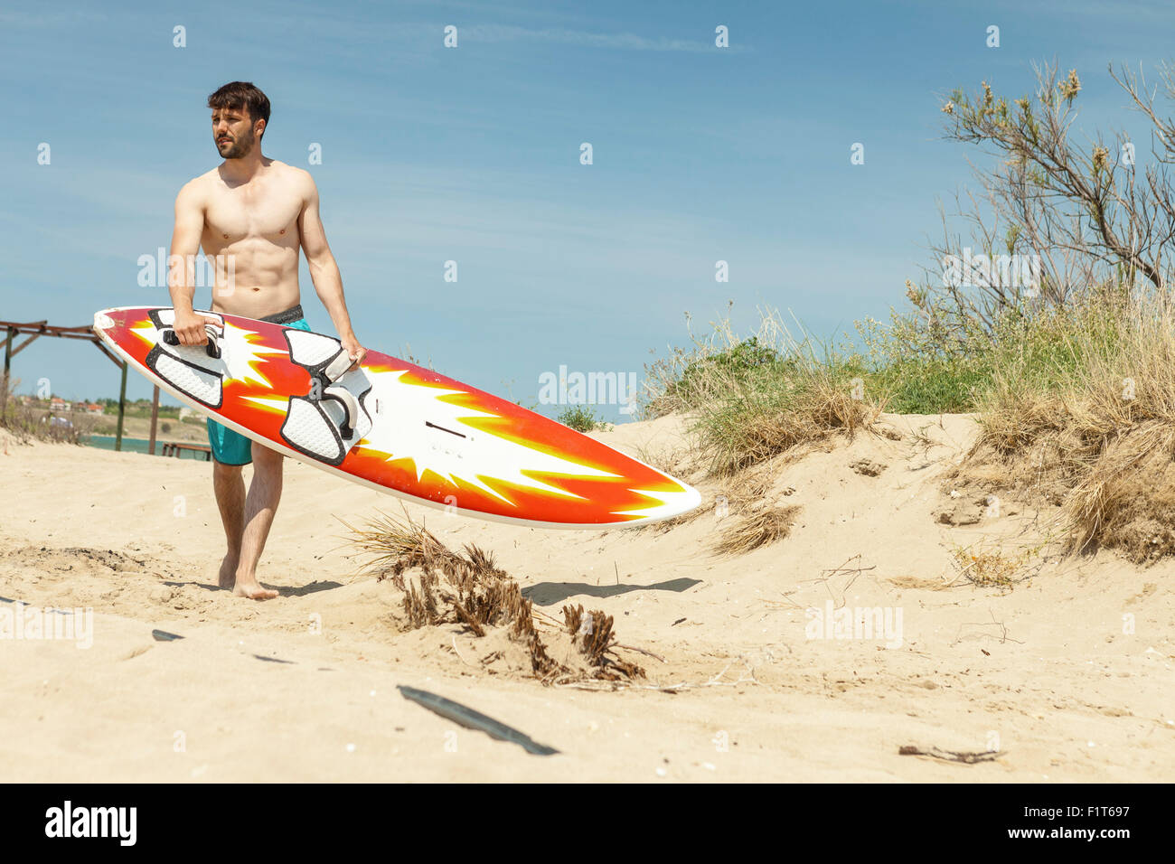 Surfista maschio sulla spiaggia Foto Stock