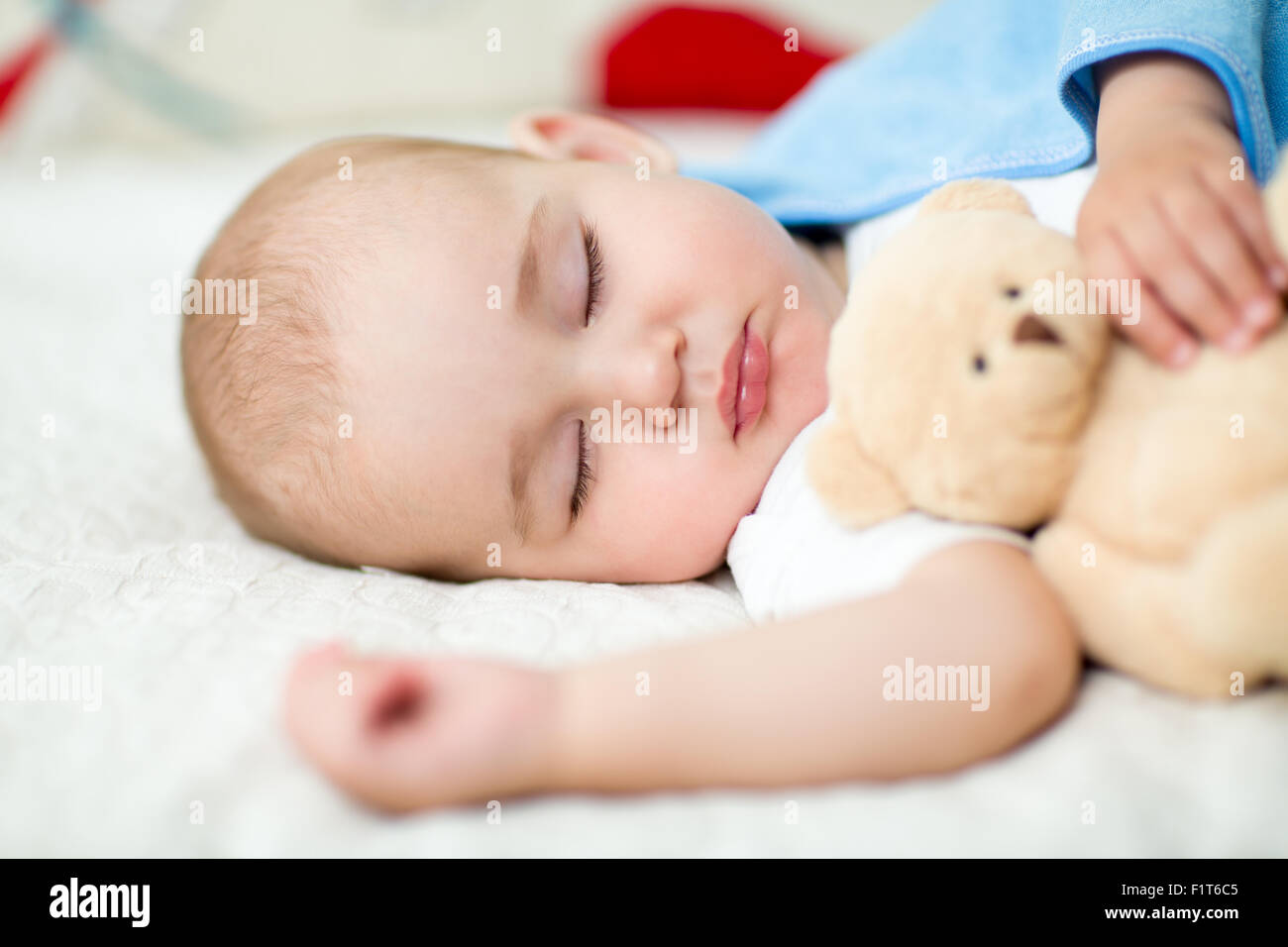 Neonato bimbo che dorme con il giocattolo di peluche Foto Stock