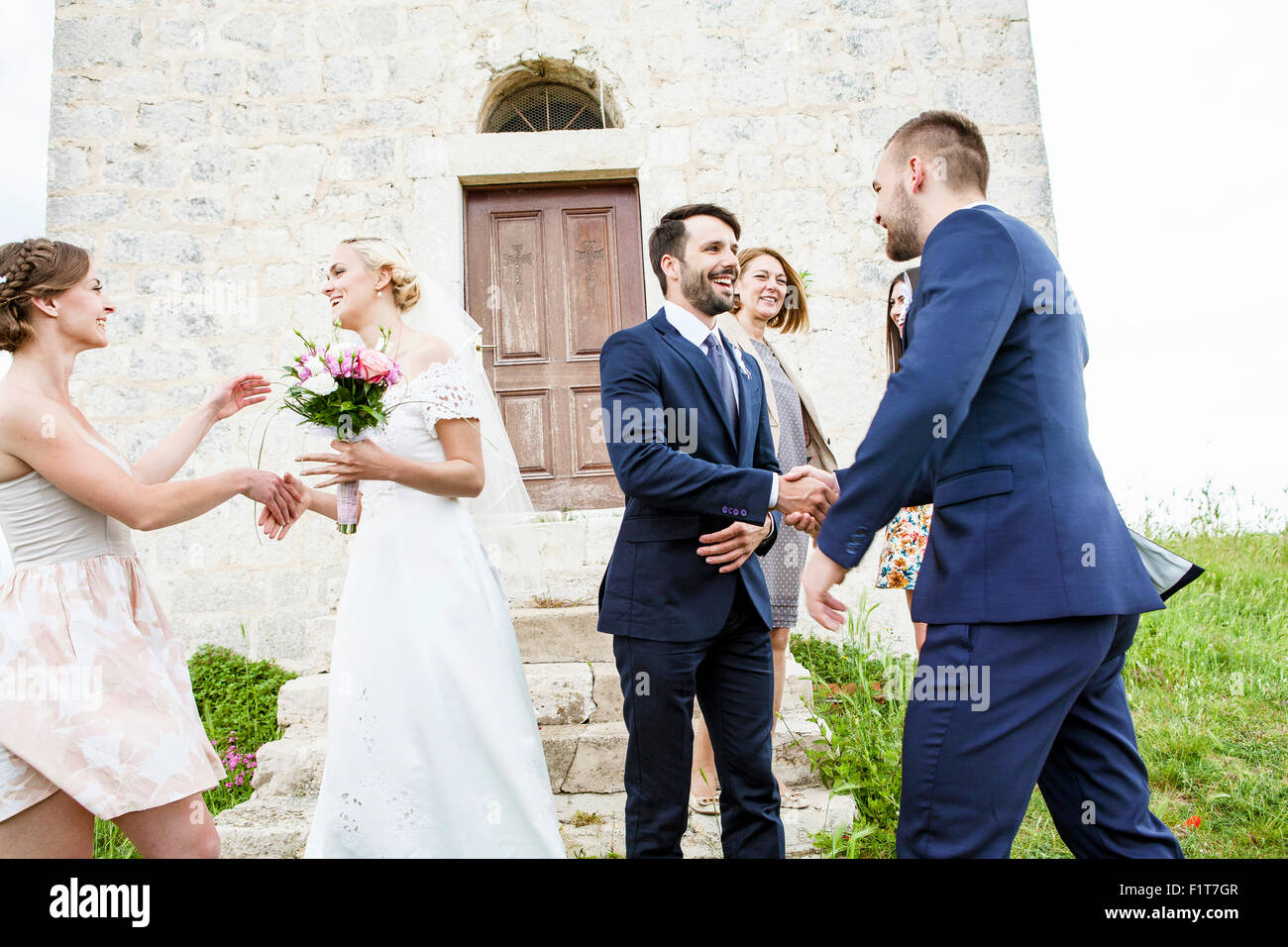 Sposa e lo sposo si stringono la mano con gli ospiti Foto Stock