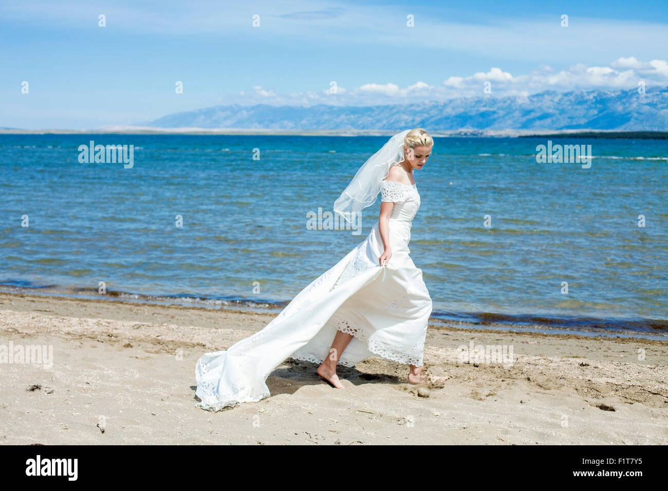 Sposa abiti da sposa camminando sulla spiaggia Foto Stock