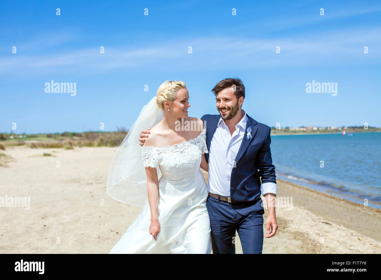 Sposa e lo sposo felicemente a piedi sulla spiaggia Foto Stock