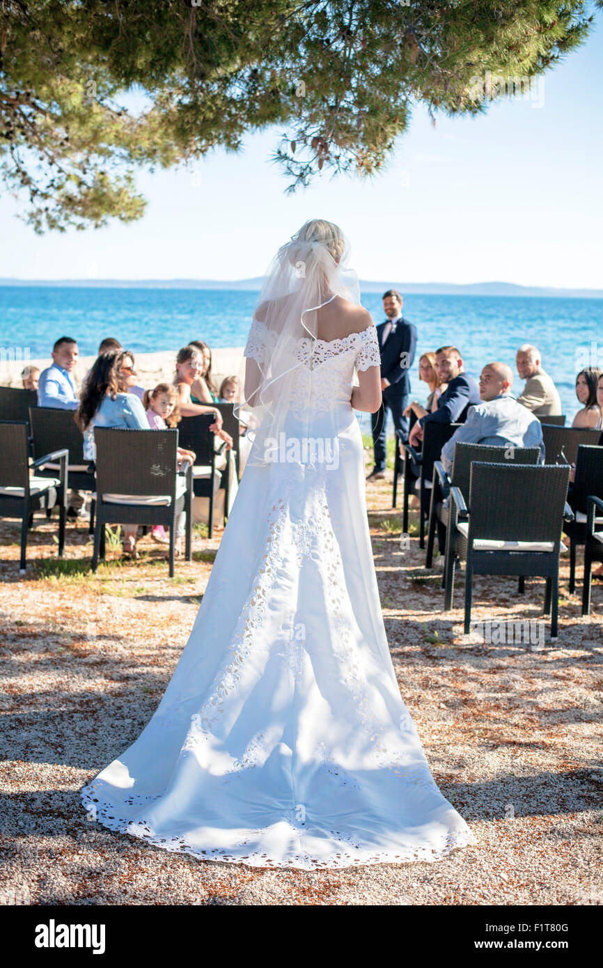 Vista posteriore della sposa alla cerimonia di nozze sulla spiaggia Foto Stock