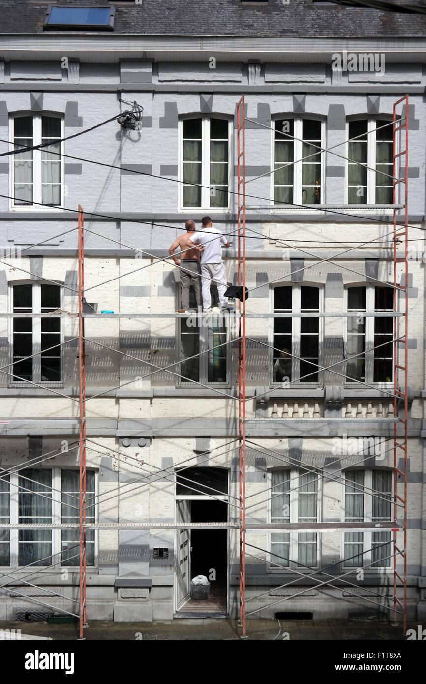 Due uomini al lavoro su ponteggi nella città belga di La Roche Foto Stock