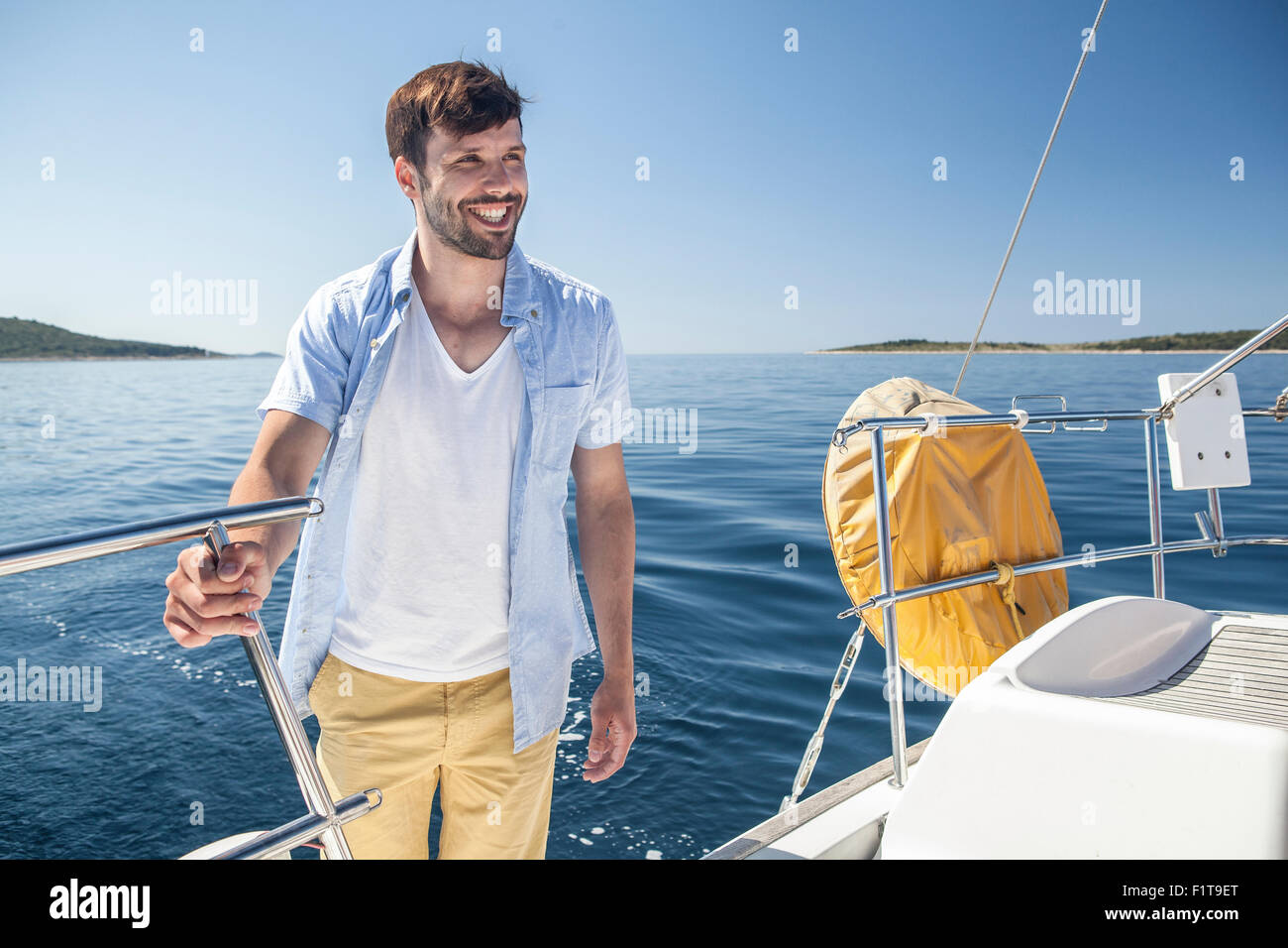 L'uomo la trattenuta sulla ringhiera sulla barca a vela mare Adriatico Foto Stock