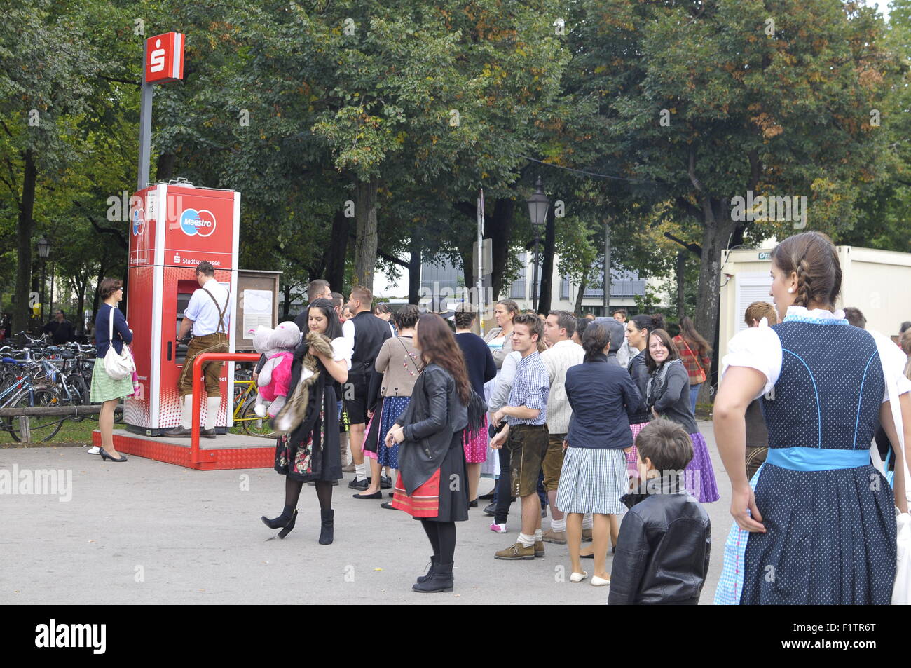 Linea in attesa per la telefonia mobile di ritirare i soldi, Oktoberfest Monaco di Baviera, Germania Foto Stock