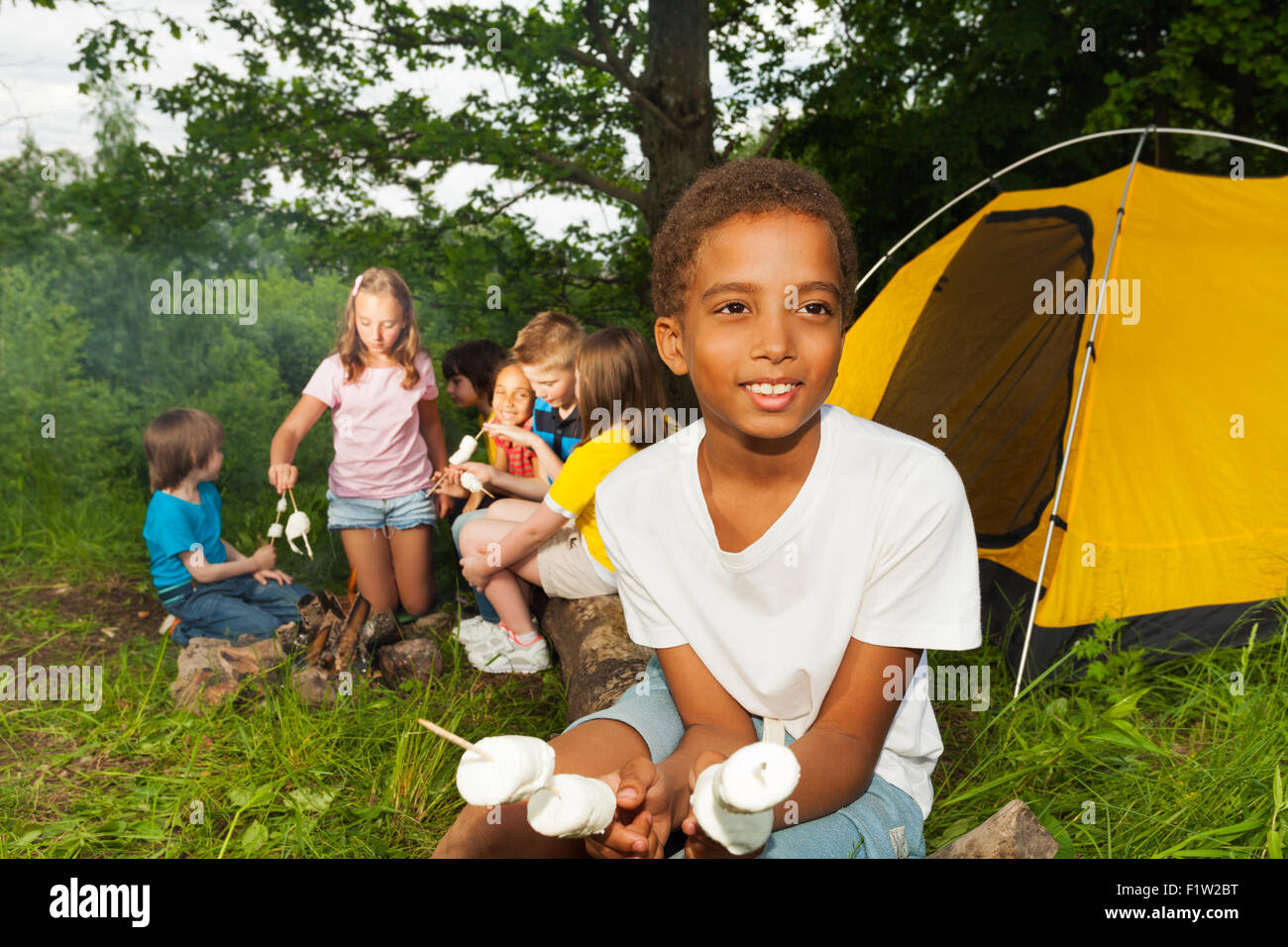 Ragazzo africano camping e azienda marshmallow Foto Stock