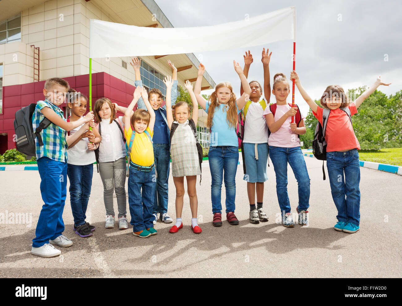 Gruppo di bambini felici con le braccia in alto targhetta in attesa Foto Stock