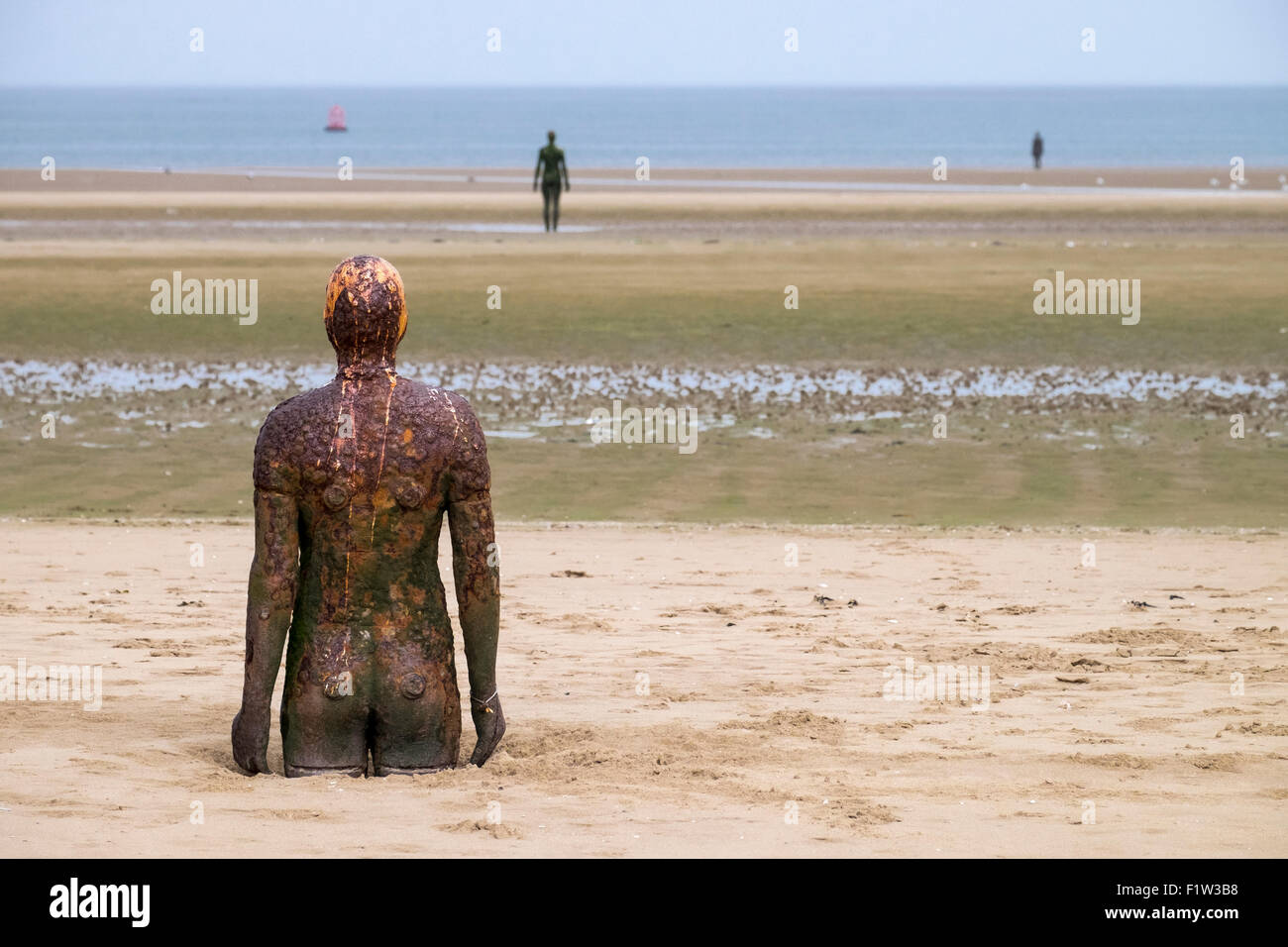 Antony Gormley sculture in altro luogo su Crosby Beach Foto Stock