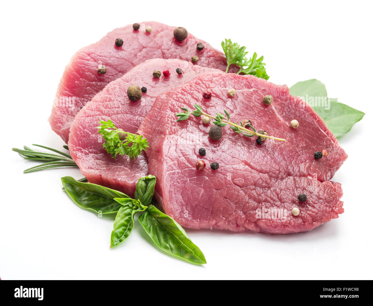 Raw bistecche di manzo con spezie su uno sfondo bianco. Foto Stock