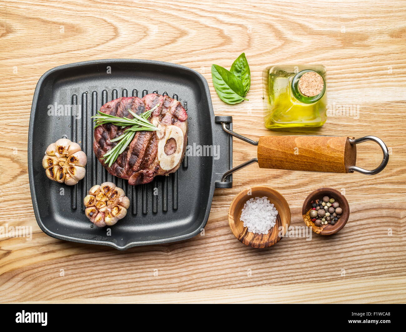 Bistecca di manzo con spezie sulla teglia su un tavolo di legno. Foto Stock