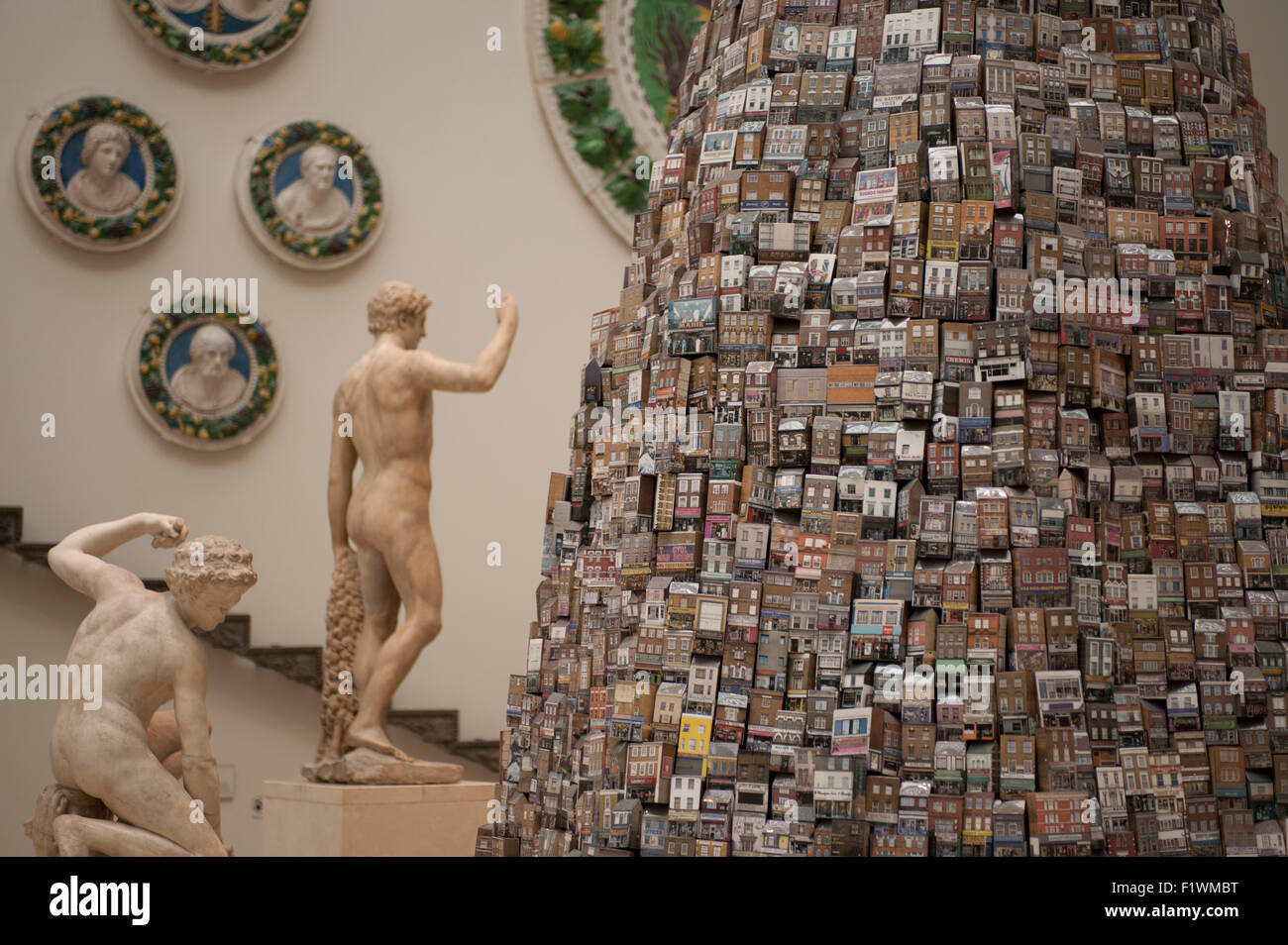 V&A, Londra, Regno Unito. 8 Settembre, 2015. Una alta 6 metri installazione creata per il V&A da artista Barnaby Barford è esposta nel museo di medievale e rinascimentale gallerie fino al 1 novembre 2015. La torre di Babele è composto da 3.000 singoli bone china edifici, ognuno raffigurante un vero e proprio negozio di Londra. La Torre di Londra riflette la società e l'economia, alla sua base i negozi sono derelitti, mentre al suo apice sono londinese di esclusive boutique e gallerie, con la torre che appaiono più precaria verso l'alto. Credito: Malcolm Park editoriale/Alamy Live News Foto Stock