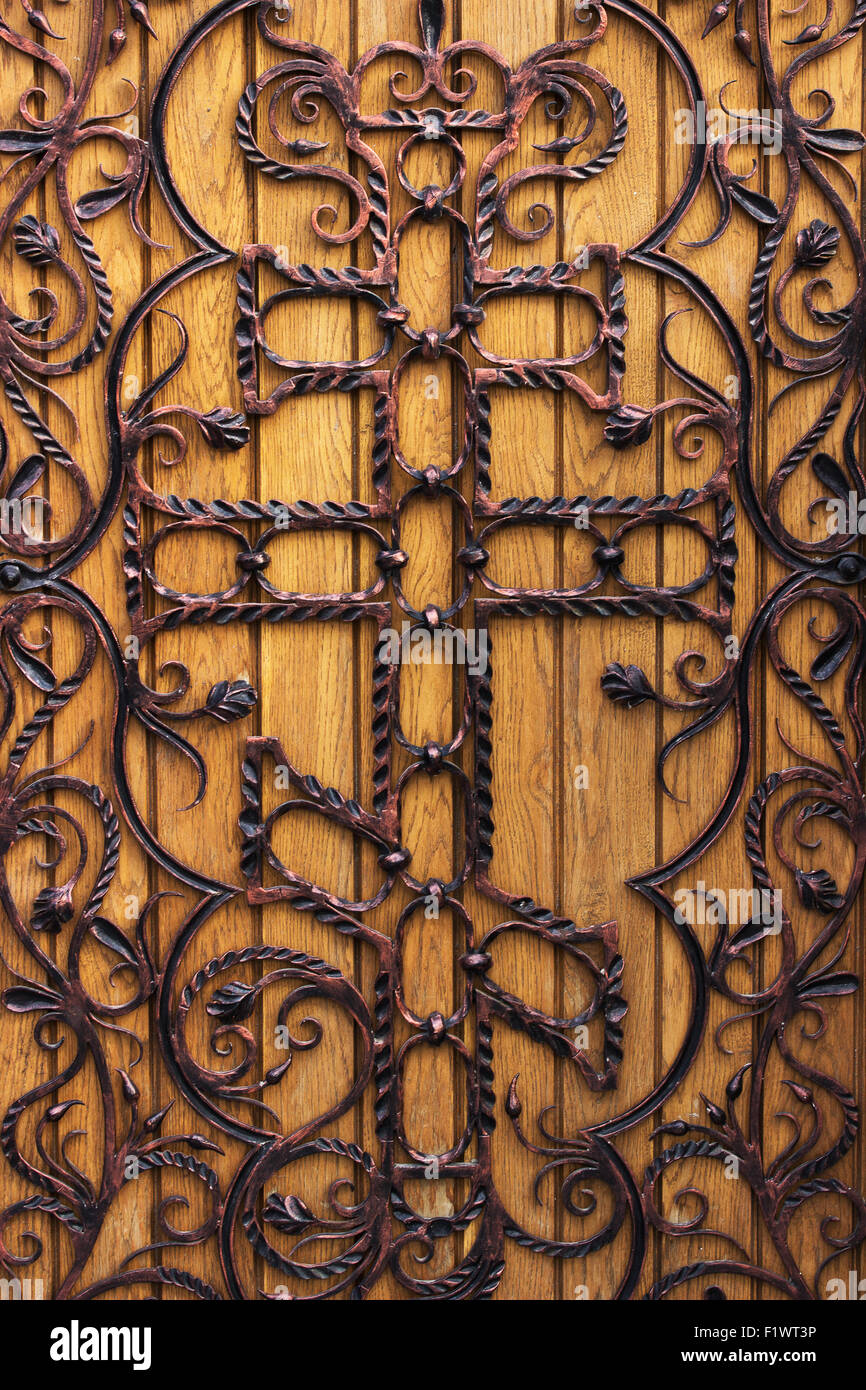 Forgiato la porta di legno con una croce nella chiesa. Foto Stock