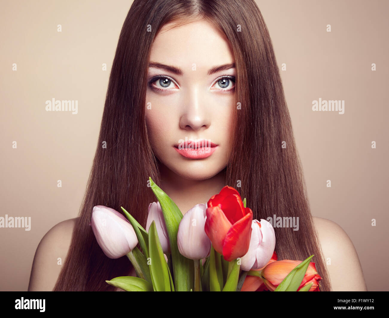 Ritratto di bella dai capelli scuri Donna con fiori. Fotografia di moda Foto Stock