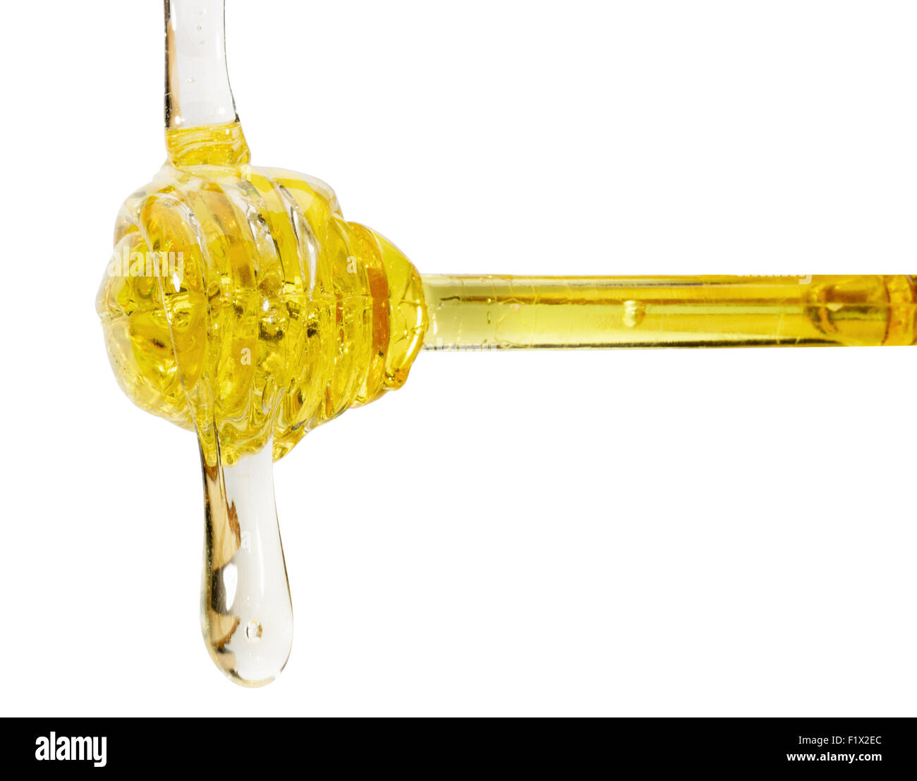 Il miele il gocciolamento da un cucchiaio su sfondo bianco. Foto Stock