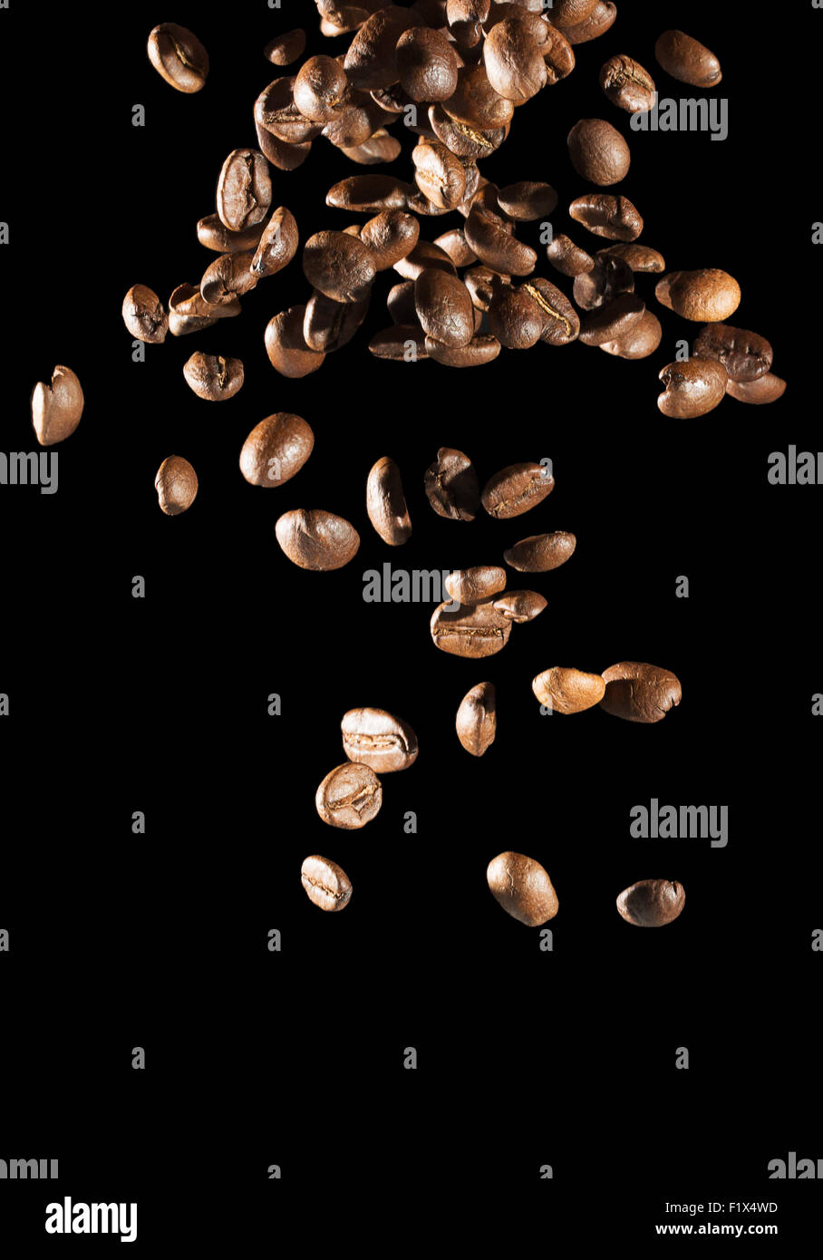 La caduta di chicchi di caffè su sfondo nero. Foto Stock