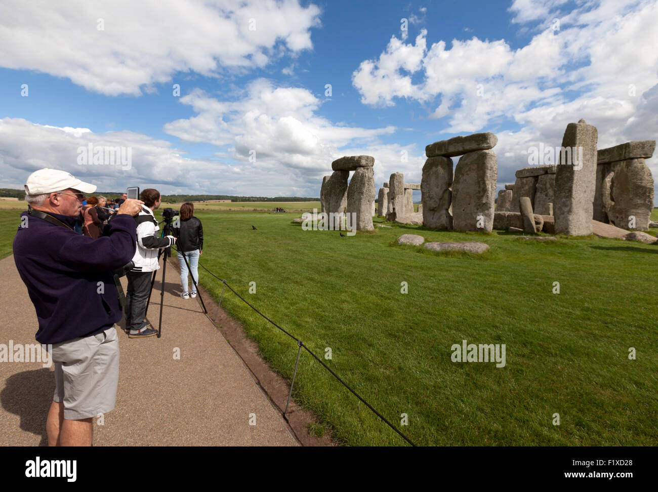 I turisti di scattare una foto di epoca preistorica Stonehenge, Sito Patrimonio Mondiale dell'UNESCO, Wiltshire, Inghilterra REGNO UNITO Foto Stock