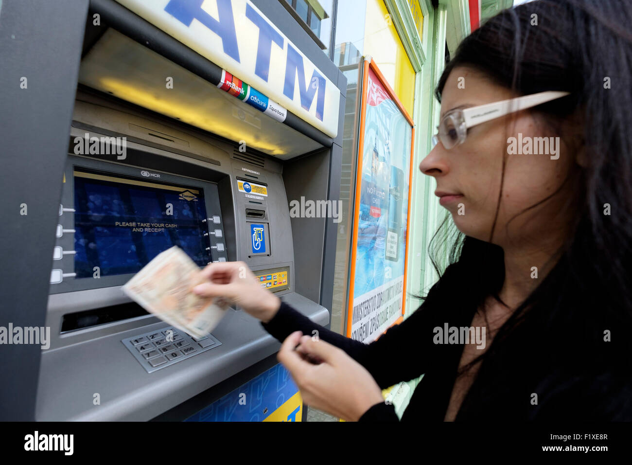 Giovane donna con bancomat per prelevare contanti Foto Stock