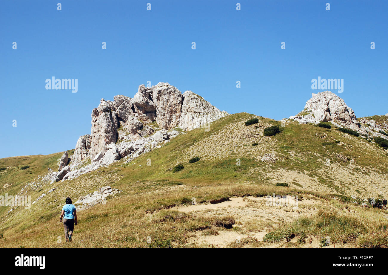 Una femmina di trekker cammina verso un punto alto nella parte superiore della Jelenak passano sul Montenegro albanese boarder Foto Stock