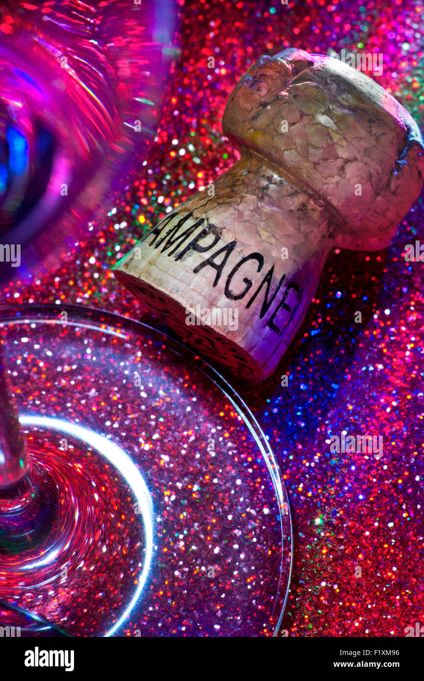 Tappo dello Champagne e vetro sulla parte frizzante la superficie del tavolo con sistema di illuminazione multicolore Foto Stock